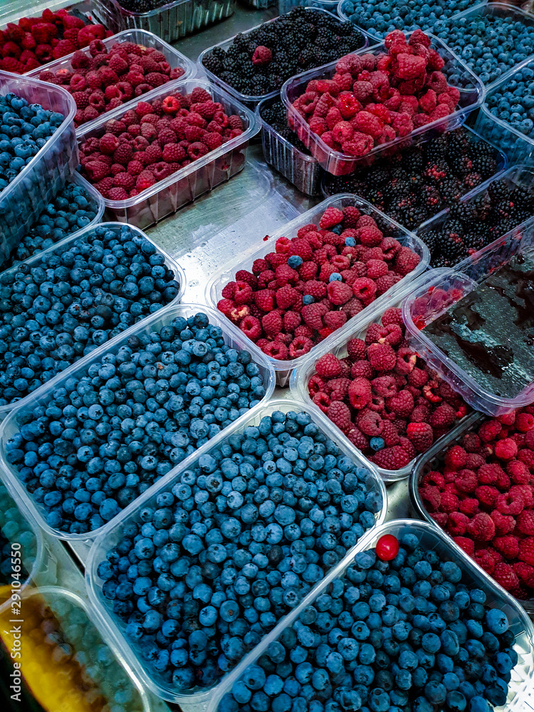 Various fresh berries Fruits in Plastic Trays on food market stall. Various fresh berries Fruits in Plastic Trays on food market stall.