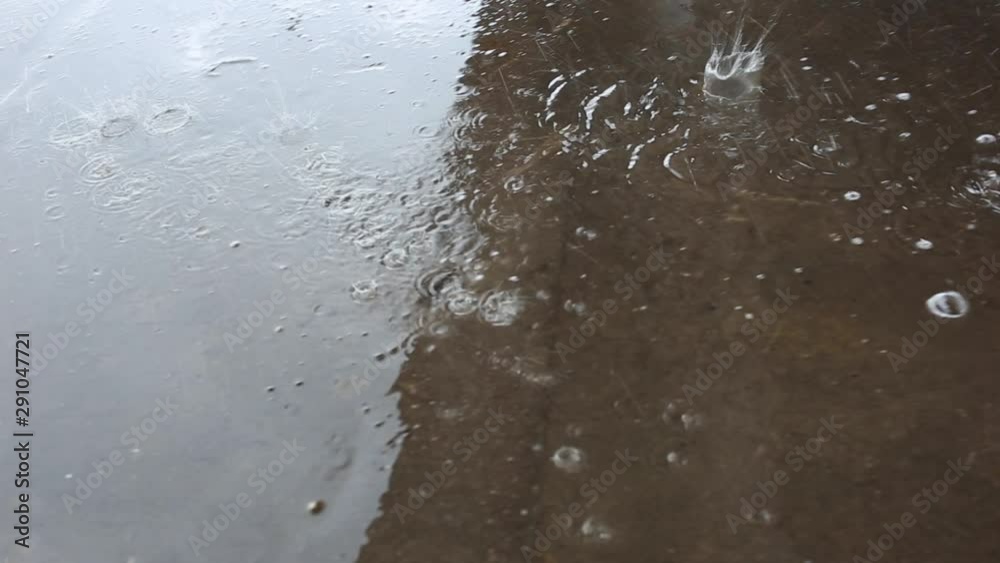 close up on raindrops falling down on puddle on rainy day in town. circle pattern on surface of wet asphalt. splashing of water. Bad weather. close up on raindrops falling down on puddle on rainy day in town. circle pattern on surface of wet asphalt. splashing of water. Bad weather.