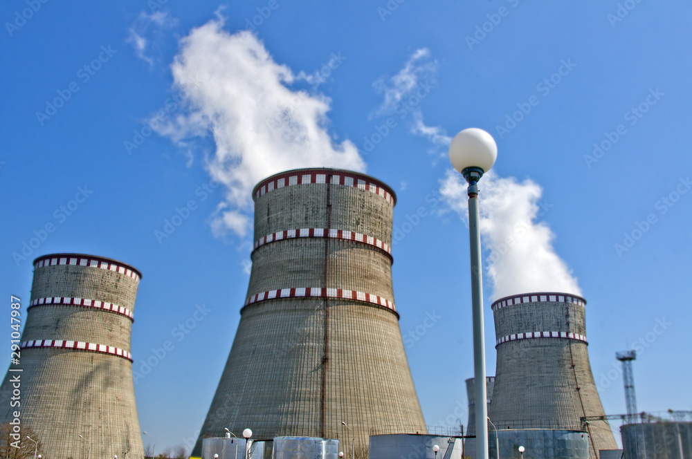 Atomic reactor. Operating nuclear power plant. Smoke from the chimney, blue sky. Power Generation