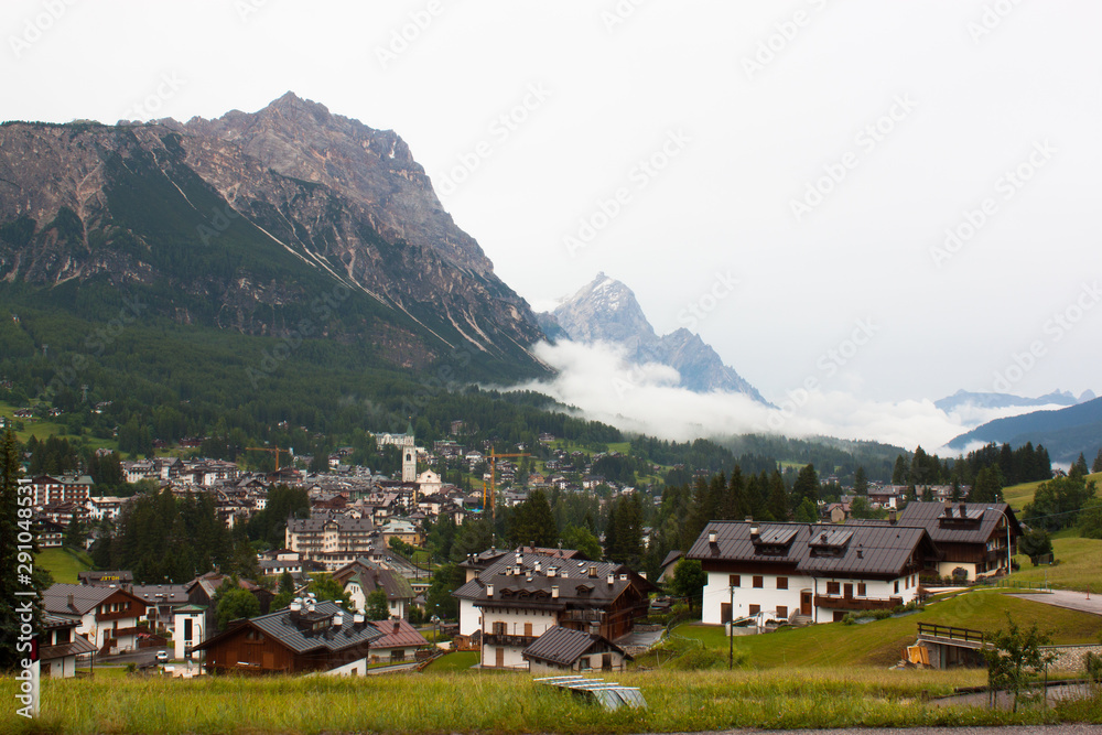 Alpen Village in Dolomites Italien Mountaun with big trees and fog and many houses