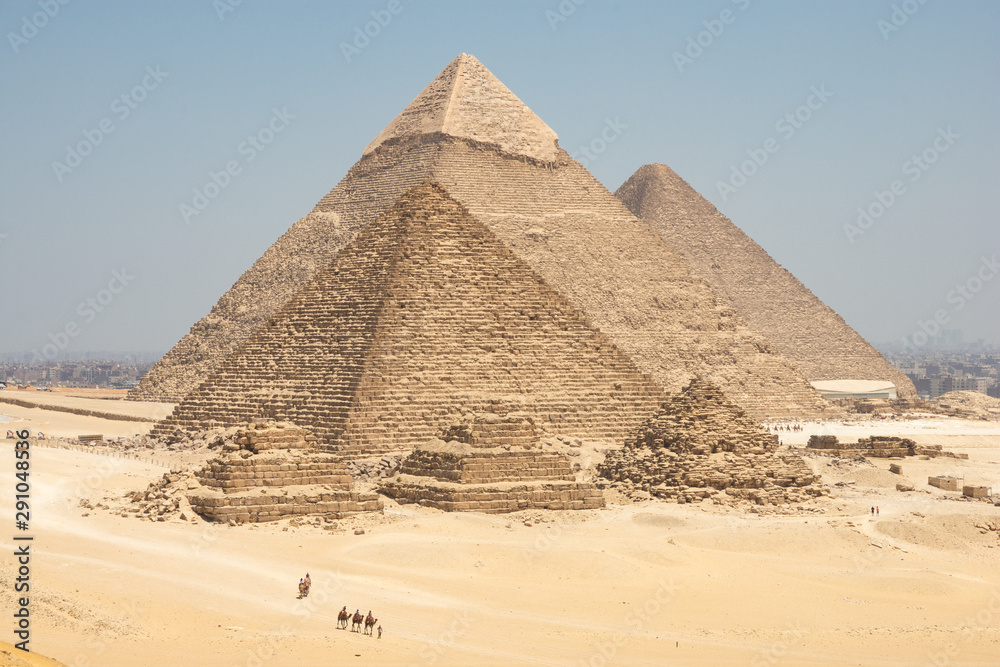 Tourists on camels are seeing Giza pyramids