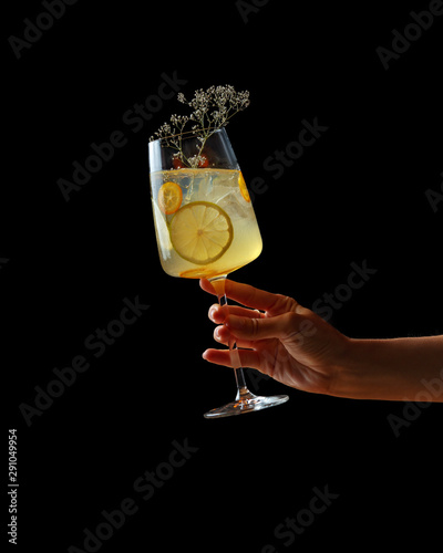 Alcoholic cocktail in a female hand on a dark background photo