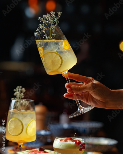 Alcoholic cocktail in a female hand on a dark background photo