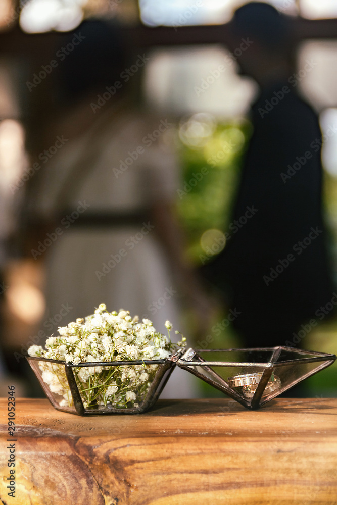 Wedding rings in a glass box with small white flowers