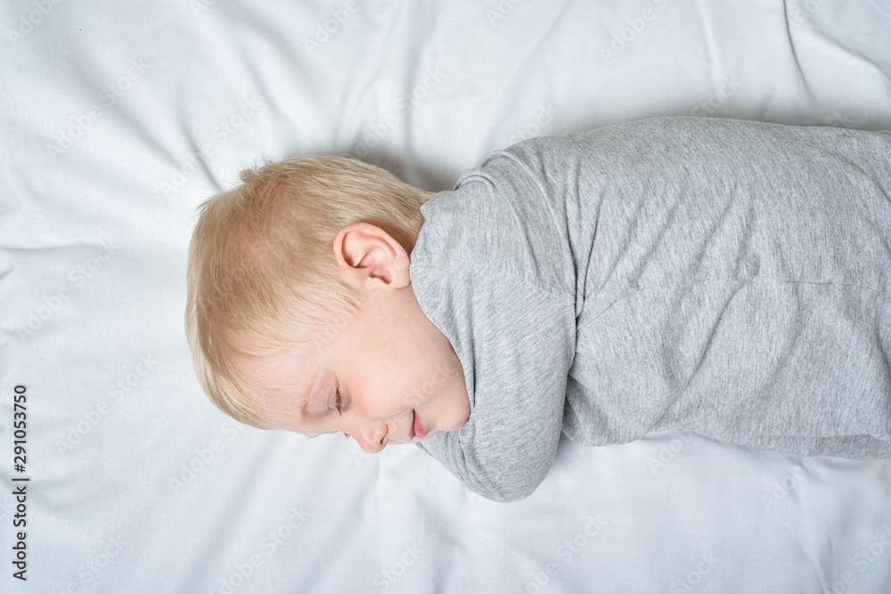 Cute blond boy sleeping with his hand under his head. White background Cute blond boy sleeping with his hand under his head. White background