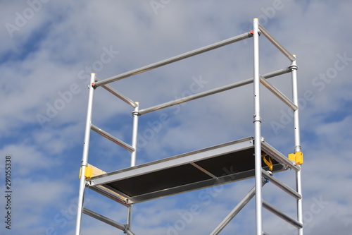 A freestanding scaffolding in front of a cloudy sky.