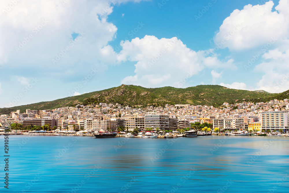 Summer view of Kavala cityscape, Greece, with blue sky, blur motion sea and scenic mountains behind the city