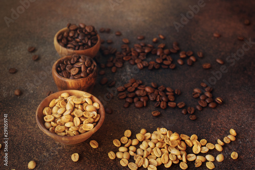 three different varieties of fresh roasted coffee beans in woden bowls