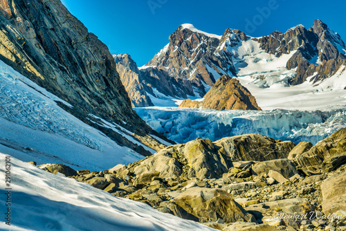 Walking on the ice and rocks of Franz Josef Glacier in the Southern Alps of New Zealand photo