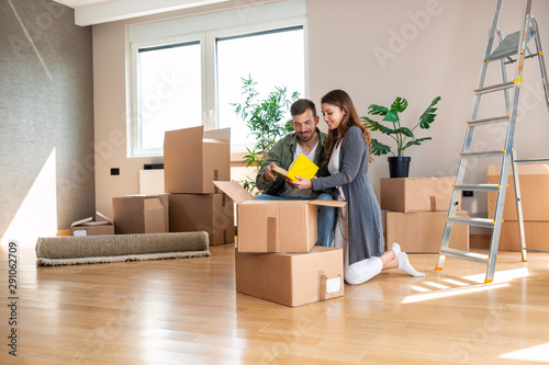 Happy couple unpacking boxes in their new apartment