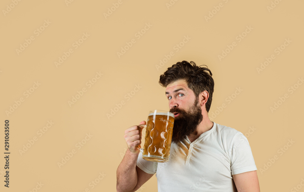 Bearded man drinking beer from glass at bar or pub. Craft beer at restaurant. Oktoberfest festival. Drink, alcohol, leisure and people concept. Bearded male tasting fresh brewed beer. Beer in Germany. Bearded man drinking beer from glass at bar or pub. Craft beer at restaurant. Oktoberfest festival. Drink, alcohol, leisure and people concept. Bearded male tasting fresh brewed beer. Beer in Germany.