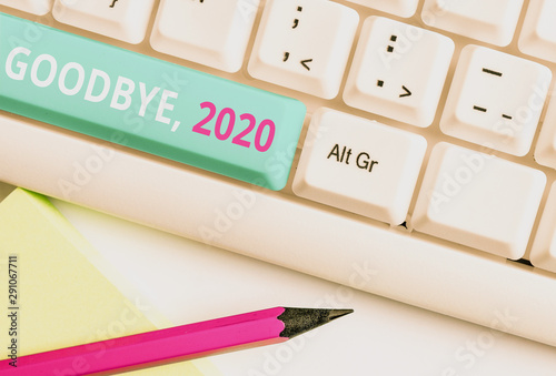 Handwriting text Goodbye 2020. Conceptual photo New Year Eve Milestone Last Month Celebration Transition White pc keyboard with empty note paper above white background key copy space photo