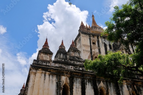 looking up to exterior corner of Thatbyinnyu Temple under sunny blue sky white clouds. The highest pahto in Bagan Myanmar. 