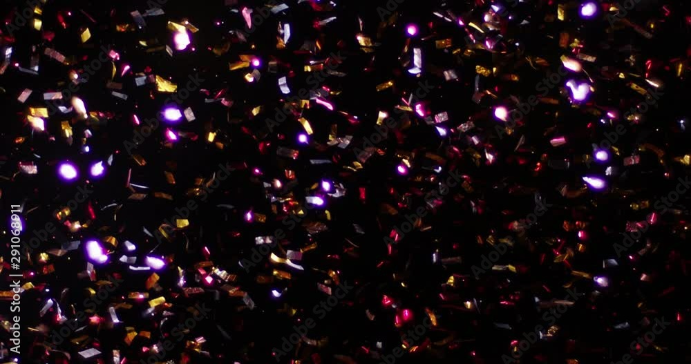 Confetti fired in the air during a party. Only confetti on black background of the night. Falling metallic glitter foil confetti multicolor in black background.