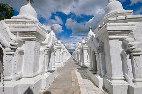 Perspective view of white stupa in Kuthodaw Pagoda, In Mandalay, Burma (Myanmar) with blue sunny sky white clouds photo