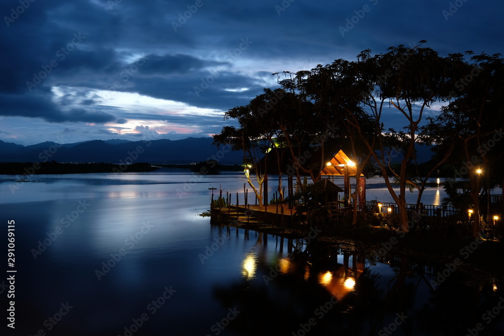 beautiful sunset of Inle lake in Shan State Myanmar. Jetty and trees silhouette above peaceful lake. Long exposure