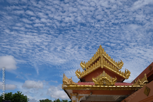 exquisite golden eaves and roof of temple in Myanmar. Blue sky white clouds copy space.