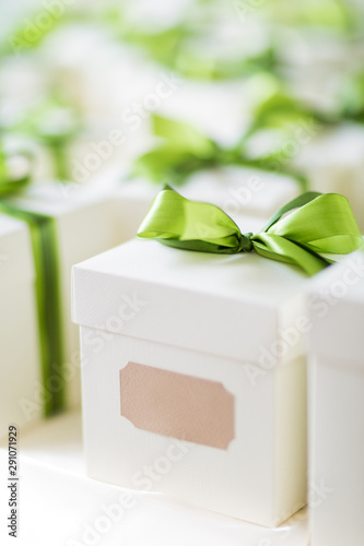 Wallpaper Mural Close up wedding favors made of white boxes with green ribbons, against a bokeh background Torontodigital.ca