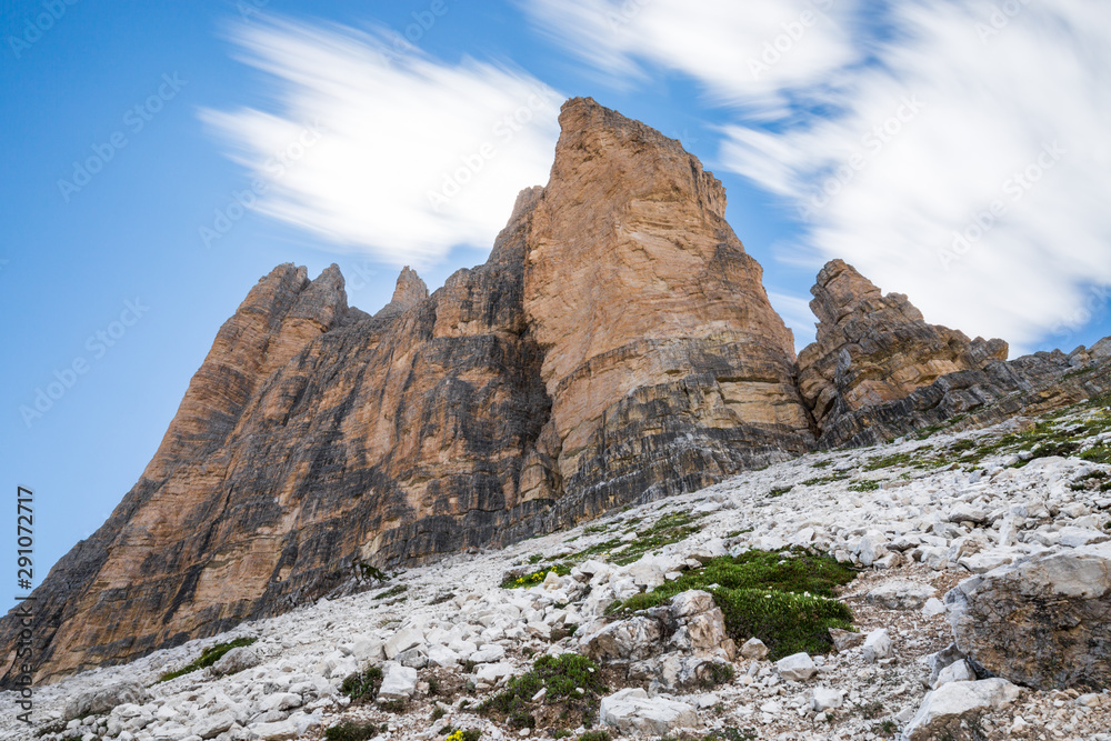 Mountain landscape with three imposing peaks agains a blue sky with trailing clouds Mountain landscape with three imposing peaks agains a blue sky with trailing clouds