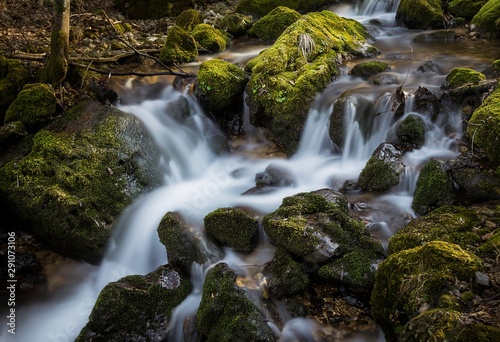 Fototapeta Naklejka Na Ścianę i Meble -  Mountain environment with a waterfall flowing between moss-covered rocks