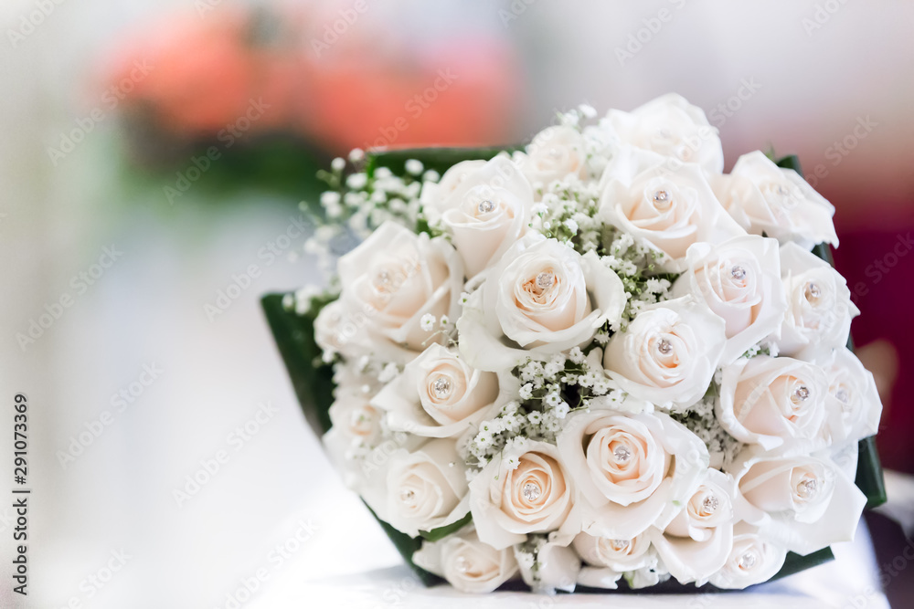 Fototapeta premium Close up of a wedding bouquet made of pale pink roses, against a bokeh background