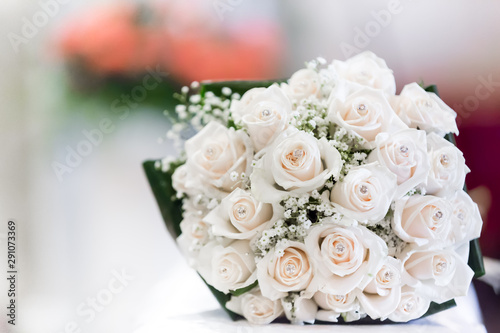 Close up of a wedding bouquet made of pale pink roses  against a bokeh background