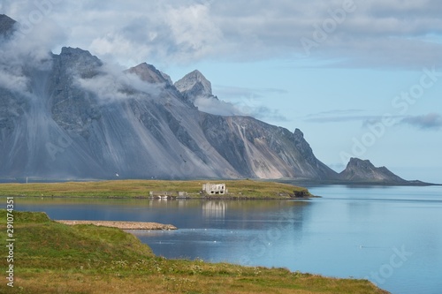 Wallpaper Mural Icelandinc landscape with the mountain range of Stokksnes sloping to the sea, under a blue sky with clouds Torontodigital.ca
