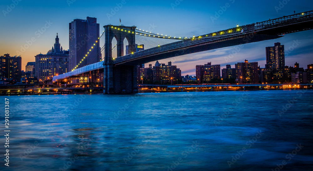 Colorful sunset on the Brooklyn Bridge with Manhattan in the background, as seen from Brooklyn Heights
