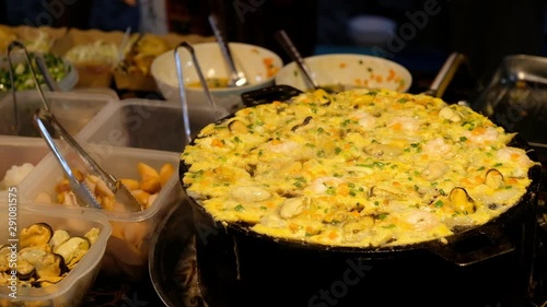 Fried clams with egg and vegetable in hot pan, thai street food, delicious