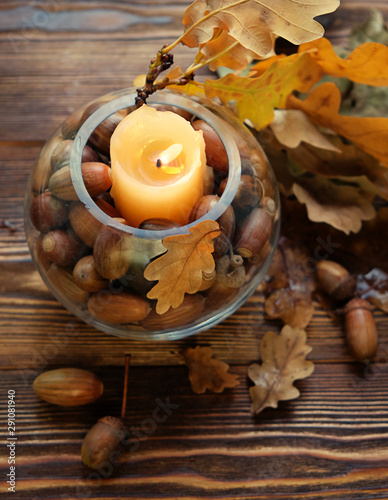 seasonal autumn composition. candle lantern, autumn oak leaves and acorns. cozy home decor, fall season. copy space. soft selective focus