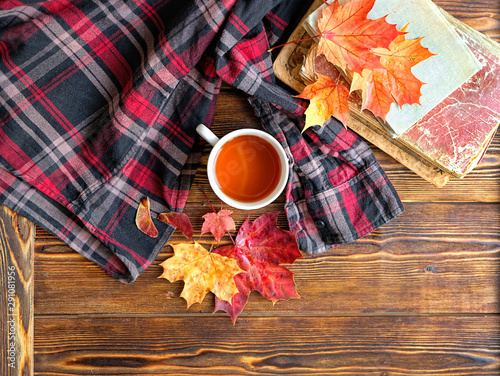 beautiful autumn composition with men s plaid shirt  book and tea. Autumn still life with tea Cup  red and yellow maple leaves. fall season concept. Top view 