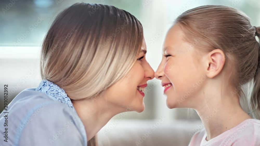 Close-up caring young mother playing touching nose with cute teen daughter feeling positive emotion Close-up caring young mother playing touching nose with cute teen daughter feeling positive emotion