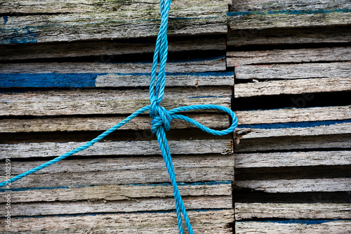 Wallpaper Mural Close up of a stack of wooden boarden held together by a blue nylon rope with a knot in the middle Torontodigital.ca