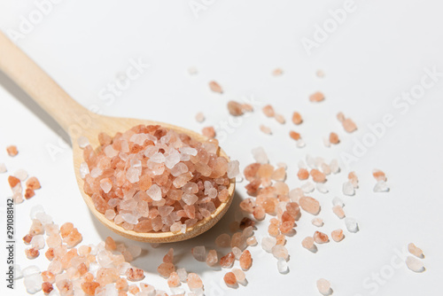Himalayan salt in wooden spoon on white background