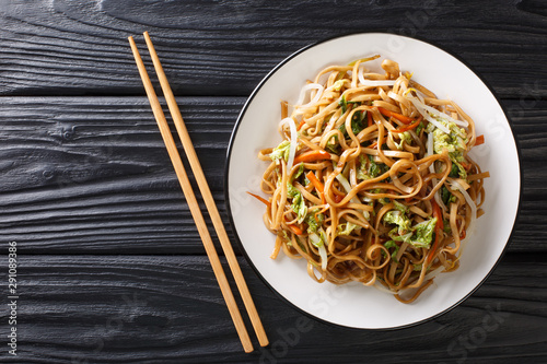 Classic Chinese fried chow mein noodles with vegetables close-up on a plate. Horizontal top view photo