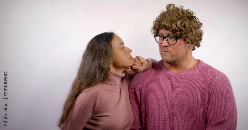 middle aged spouses are communicating standing in room with white wall middle aged spouses are communicating standing in room with white wall
