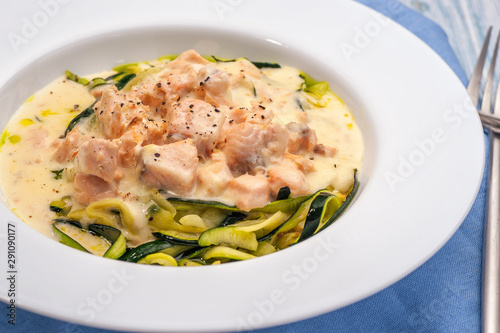 Salmon slices in creamy sauces and zucchini.
