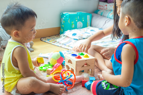 Group of children playing together with wooden toy box