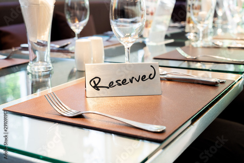Reserved Metal Plate on the Table with Blurry background. Reservation Seat at restaurant.