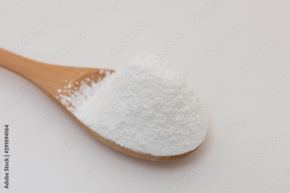 Close-up of tapioca starch or flour powder in wooden spoon with white background isolated Close-up of tapioca starch or flour powder in wooden spoon with white background isolated