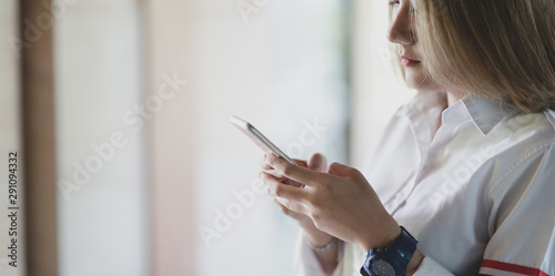 Close-up view of young businesswoman looking for new informations on smartphone
