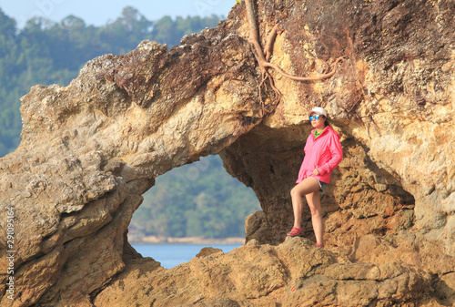 Beautiful thai woman on the rocks by the sea