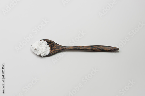 Top view of starch or flour powder on wooden spoon isolated white background