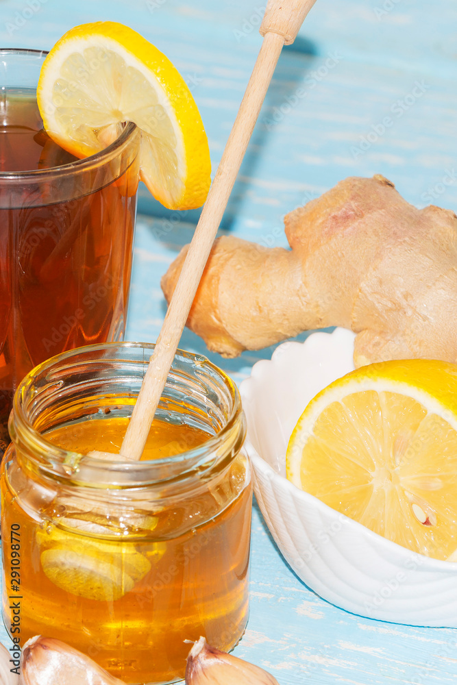 Cup of natural tea with ginger, lemon and honey on a light background. Healthy drink. The concept of a hot winter drink. Cup of natural tea with ginger, lemon and honey on a light background. Healthy drink. The concept of a hot winter drink.