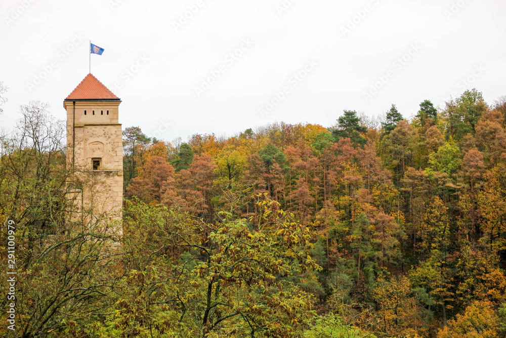 Main tower of old medieval castle Veveri surrounded by colorful autumn forest, Czech republic