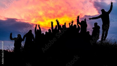 Silhouette  group of happy people jumping in sunset - image