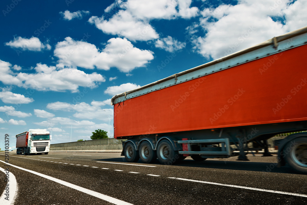 Red trucks is on highway - business, commercial, cargo transportation concept, clear and blank space on the side view