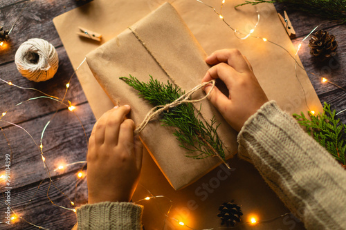 Hands Gift wrapping in eco style, christmas photo