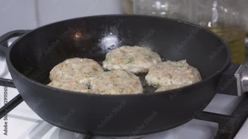 Making pan fried chicken cutlets in cast iron frying skillet with oil on gas stove. Making pan fried chicken cutlets in cast iron frying skillet with oil on gas stove.