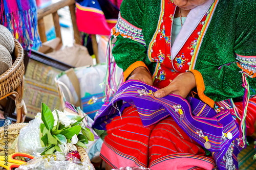 Closeup hands of Thailander Hill tribe ladies are demonstrating the sewing and decorating of costumes for tourists in her village.